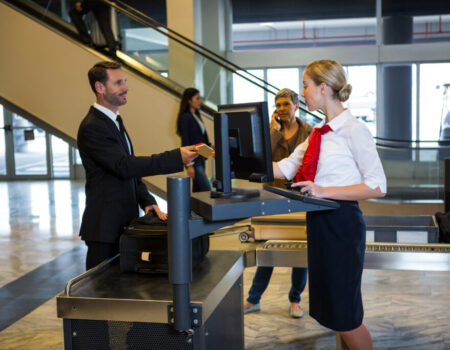 Female staff interacting with passenger at the airport terminal